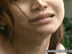 水のホースで浸したアジアのベイビーを縛った